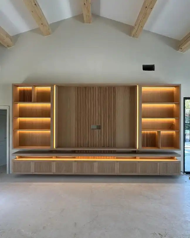 Modern living room with custom built-in entertainment center, exposed wood beams, and vaulted ceiling