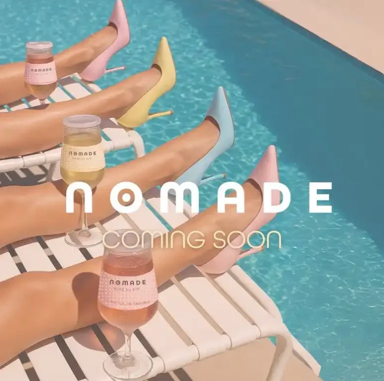 Lifestyle brand teaser featuring pastel heels poolside with wine glasses and NOMADE coming soon typography